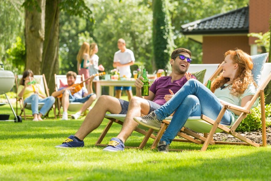 A group of people talking and enjoying their backyard. 