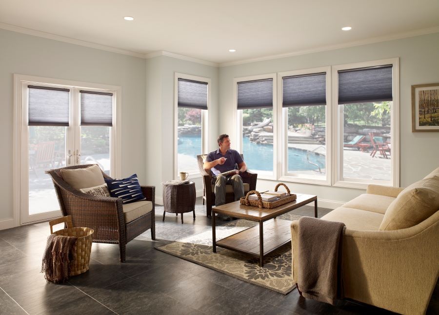  A sunroom overlooking a pool, with the shades partially drawn.