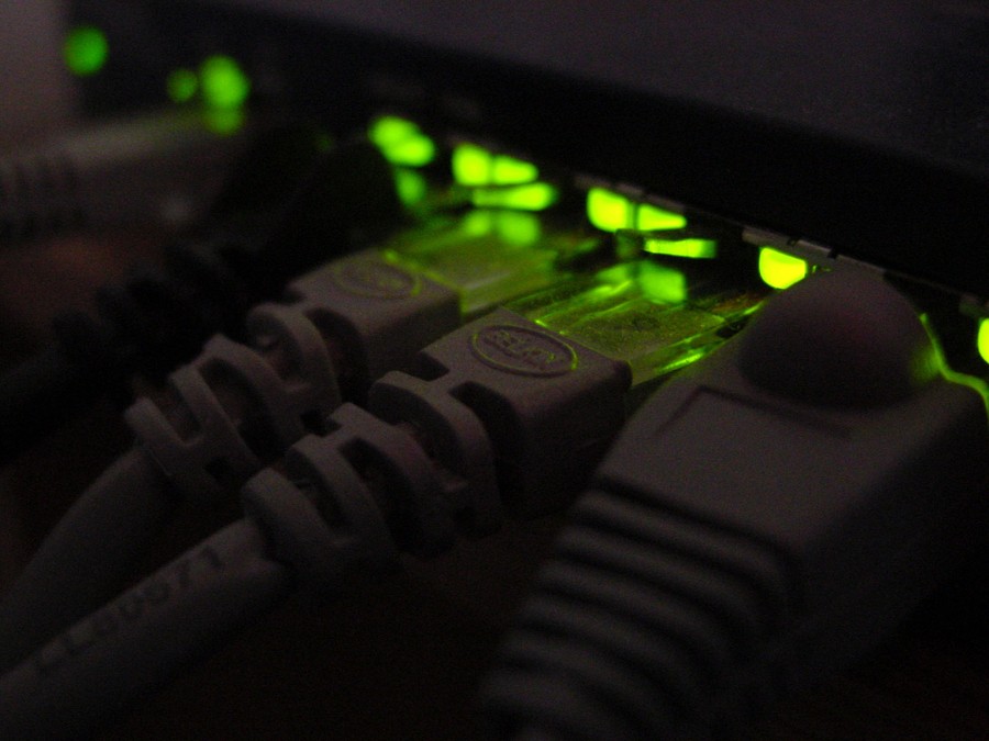 cables connected to ports in a wi-fi router with green lights