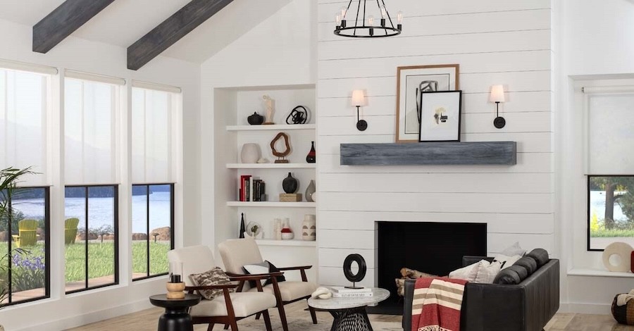 A rustic-chic living room with windows open displaying a lake nearby.